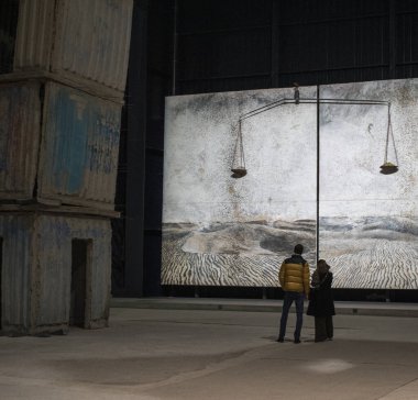 Milan, İtalya, 5-12-2021: Ziyaretçiler Alchemie 'ye (Alchemy), Alnselm Kiefer tarafından yan yana dizilmiş iki tuvale, Pirelli Hangar Bicocca' da kalıcı bir tesise, modern ve çağdaş sanat eserlerinin sergilendiği yere bakıyorlar.