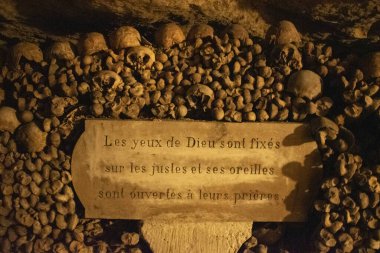 Paris, Fransa: Kafatasları, kemikleri ve Fransız yazıtları Tanrı 'nın gözleri erdemlilere sabitlenmiştir ve kulakları, 6 milyondan fazla insanın kalıntılarıyla bir yeraltı taş ocağının ünlü ossuaresi olan Paris Yeraltı Mezarlığı' ndaki dualarına açıktır.