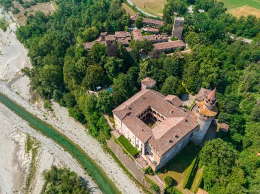 İtalya 'nın Emilia-Romagna eyaletindeki Trebbia nehri üzerindeki Rivalta kalesinin hava manzarası. 06-16-2022 Silindirik kulesi ile güçlendirilmiş görkemli bir kompleks..