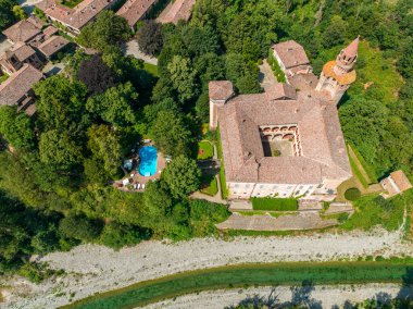 İtalya 'nın Emilia-Romagna eyaletindeki Trebbia nehri üzerindeki Rivalta kalesinin hava manzarası. 06-16-2022 Silindirik kulesi ile güçlendirilmiş görkemli bir kompleks..