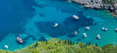 Aerial view of boats close to Limni Beach Glyko, on the island of Corfu. Greece. Where the two beaches are connected to the mainland providing a wonderful scenery. Unique double beach