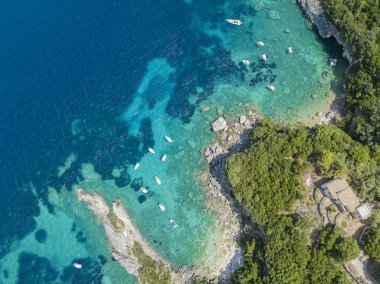 Korfu adasındaki Klimatia plajı ile Limni plajı arasındaki kayaların hava manzarası. Kıyı şeridi. Şeffaf ve kristal su, demirli tekneler ve banyolar. Tatilde. Yunanistan