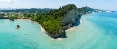 Apotripiti sahili yakınlarındaki deniz manzaralı uçurum ve kristal berrak deniz kıyısındaki deniz kızı kayası. Korfu Adası, Yunanistan, İyon Denizi