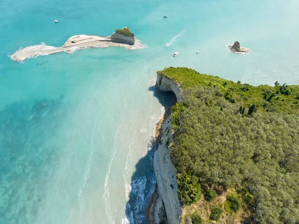 Aerial view of the cliff overlooking the sea near Apotripiti beach and of Mermaid\'s rock, a promontory on the crystal clear sea. Corfu island, Greece, Ionian sea.