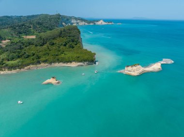 Aerial view of the cliff overlooking the sea near Apotripiti beach and of Mermaid's rock, a promontory on the crystal clear sea. Corfu island, Greece, Ionian sea.