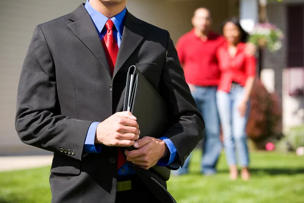 Home: Agent met huizenkopers achter hem — Stockfoto