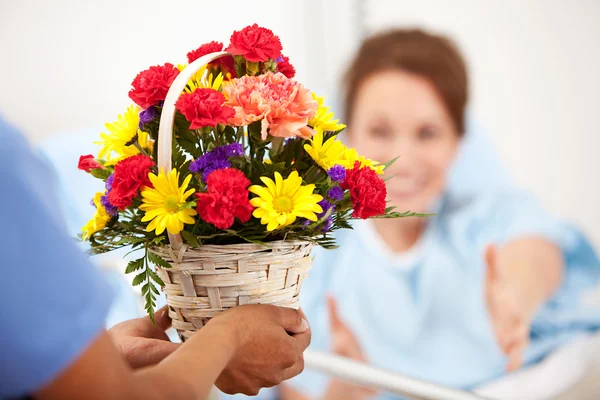 Hastane: Kadın çiçek hediye için ulaşır. — Stok fotoğraf