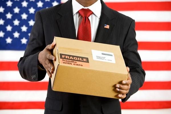 Político: Segurando uma caixa de papelão para enviar — Fotografia de Stock