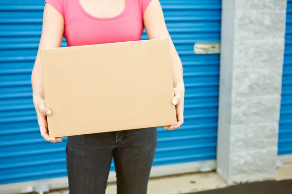 Storage: Woman With Box Stands By Door — Stock Photo, Image