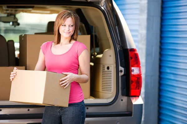 Storage: Woman Lifts Box from Truck Stock Photo