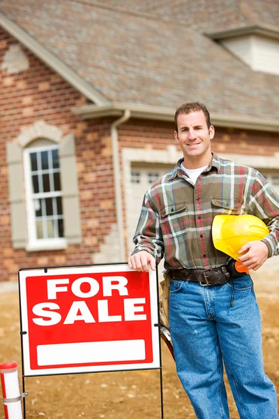 Konstruktion: Builder står vid försäljning tecken — Stockfoto