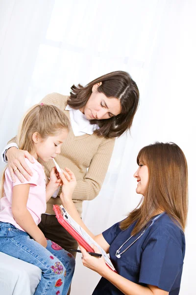 Krankenschwester: Krankenschwester nimmt Temperatur von kleinem Mädchen — Stockfoto