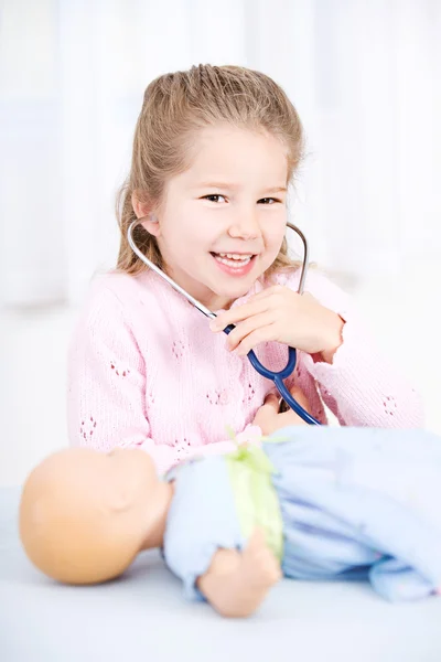 Enfermeira: Menina jogando enfermeira com boneca — Fotografia de Stock