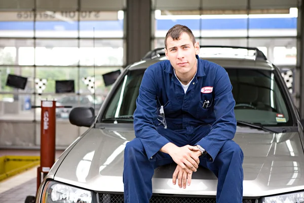 Mechanic: Mechanic Sits on SUV Hood — Stock Photo, Image