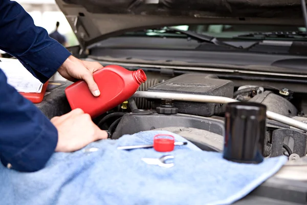 Mechanic: Olie gieten in motor — Stockfoto