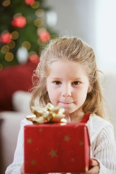 Weihnachten: kleines Mädchen hält Weihnachtsgeschenk in der Hand — Stockfoto