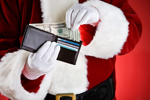 Weihnachtsmann: Bargeld aus der Brieftasche ziehen — Stockfoto