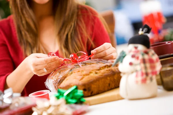クリスマス: 女性のバナナのパンの贈り物をラップ — ストック写真
