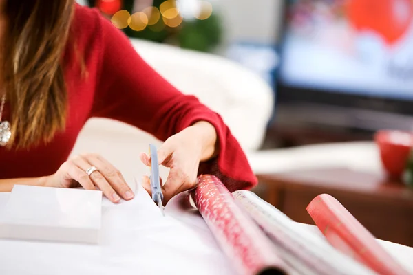 Natal: Mulher cortando papel de embrulho — Fotografia de Stock