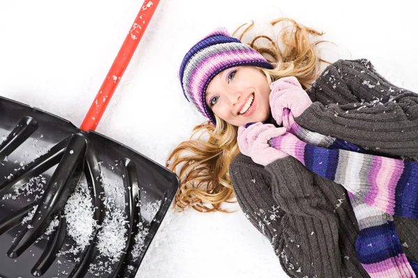 Invierno: Mujer bonita acostada junto a la pala de nieve —  Fotos de Stock