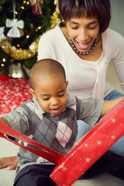 Família: Garoto bonito desembrulhando presente de Natal — Fotografia de Stock