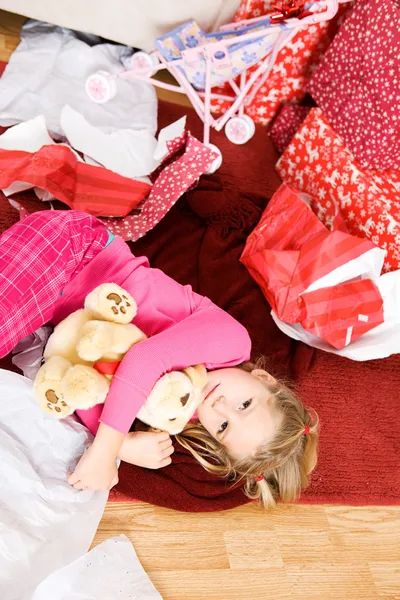 Navidad: Niña acostada en el suelo en papel de embalaje —  Fotos de Stock