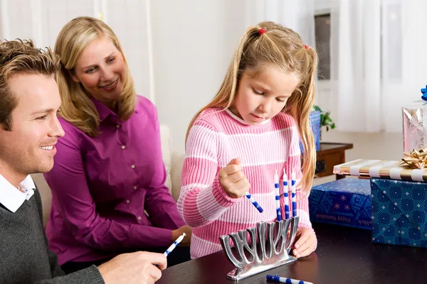 Hanukkah: Girl Puts Candles in Menorah Stock Photo