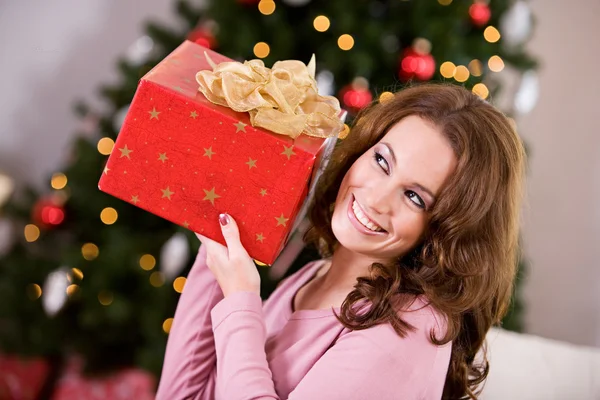 Navidad: Mujer tratando de adivinar regalo de Navidad —  Fotos de Stock