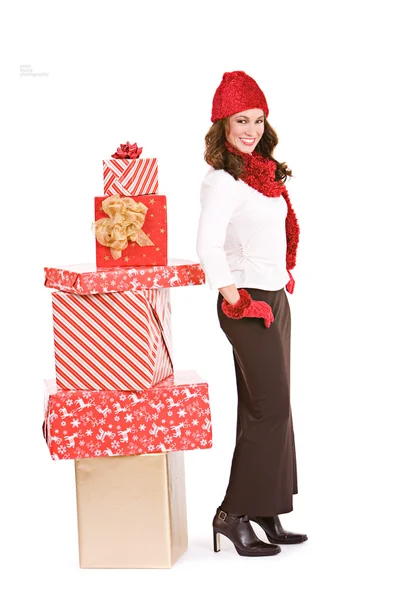 Kerstmis: winter vrouw standying door stack van geschenken — Stockfoto