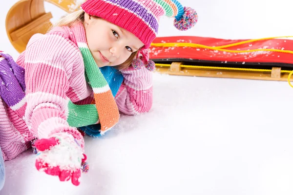 Vinter: liten släde flicka med handfull snö — Stockfoto