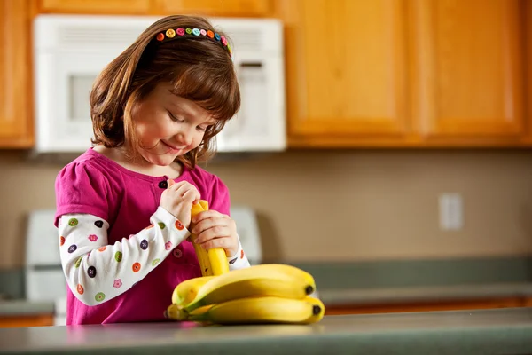 Kuchyně dívka: připravené k jídlu banán — Stock fotografie