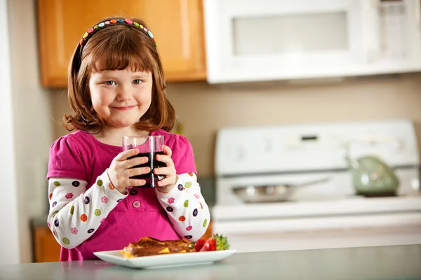 Κουζίνα κορίτσι: έχοντας χυμό με γεύμα — Φωτογραφία Αρχείου