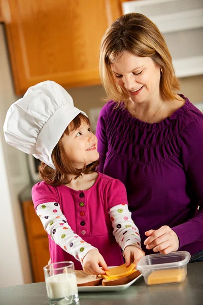 Кухня дівчина: приготування їжі з мамою — стокове фото