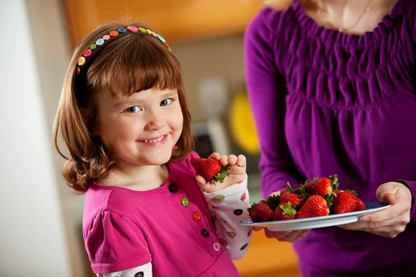 Kitchen Girl: Taking a Berry from a Plate — Stock Image Kitchen Girl: Taking a Berry from a Plate Royalty Free Stock Photos