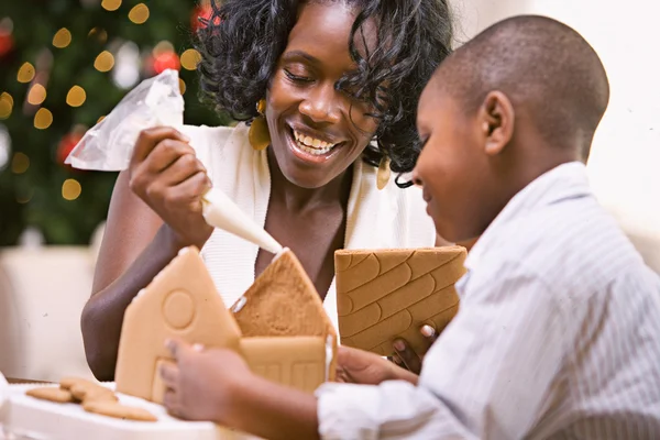 圣诞节： 母亲和儿子建立假日姜饼屋 — 图库照片
