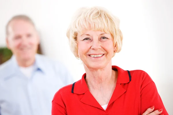 Seniors: Woman Looking At Camera with Man Behind — Stock Photo, Image