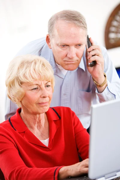 Пенсионеры: пара по телефону с технической поддержкой — стоковое фото