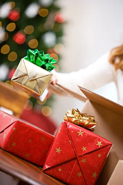 Navidad: Regalos de embalaje de mujer en caja de envío — Foto de Stock