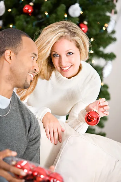 Natal: Homem que ajuda a mulher a decorar árvore de Natal — Fotografia de Stock