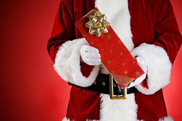 Santa: Mãos cheias de presentes de Natal — Fotografia de Stock