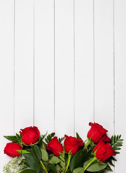 Valentine 's: Rosas vermelhas em fundo de madeira branca — Fotografia de Stock