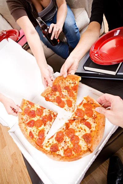 Studenten: vrienden bereiken in om stukje pizza te grijpen — Stockfoto