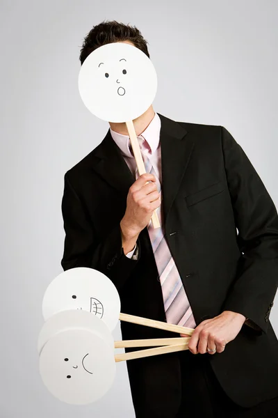 Förklädnad: affärsman som gömmer sig bakom förvånade ansikte — Stockfoto