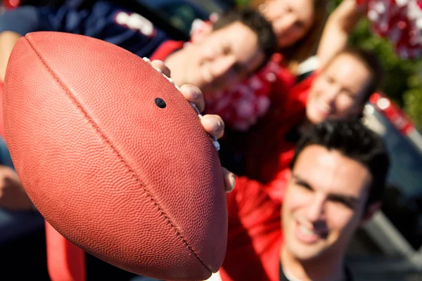 Tailgating: Man Holds Football Out To Camera Stock Picture