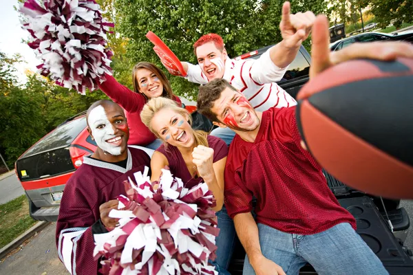 Tailgating: Grupo de estudantes universitários animado para o jogo de futebol Imagens De Bancos De Imagens