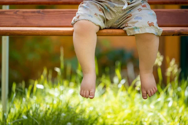 Aufwachkonzept Barfuß Auf Parkbank Sitzende Babyfüße Großaufnahme Sommerzeit Stockfoto