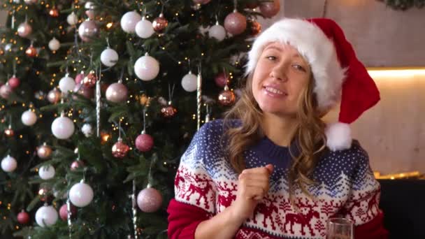Een Meisje Verkleed Als Kerstman Danst Achtergrond Van Een Kerstboom — Stockvideo