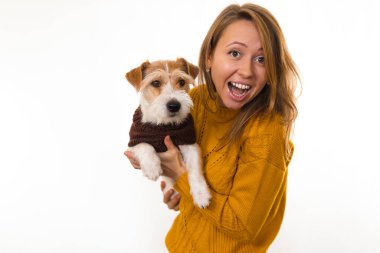 Sarı ceketli gülen kız kollarında bir köpek tutuyor. Beyaz arkaplanda izole et.