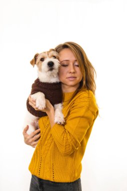 Sarı ceketli bir kız Jack Russell Terrier köpeği tutuyor. Beyaz arkaplanda izole et.