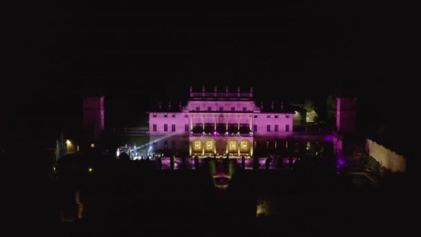 Vista aérea nocturna de una hermosa villa italiana iluminada en púrpura y amarillo — Vídeos de Stock